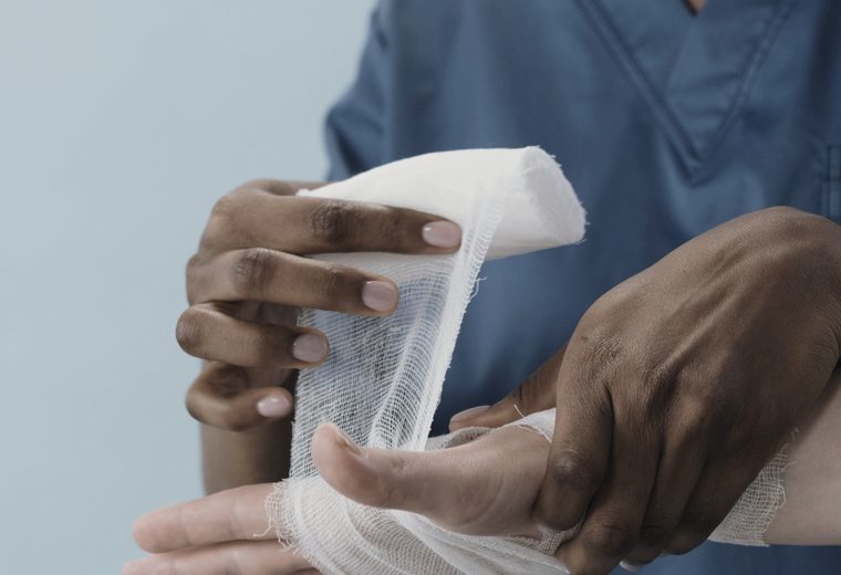Medical professional bandaging an injured hand